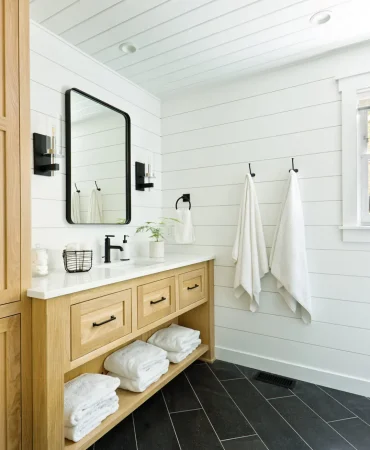 A contemporary modern bathroom design for a country home cabin. featuring a classic freestanding vanity and linen storage cabinet.